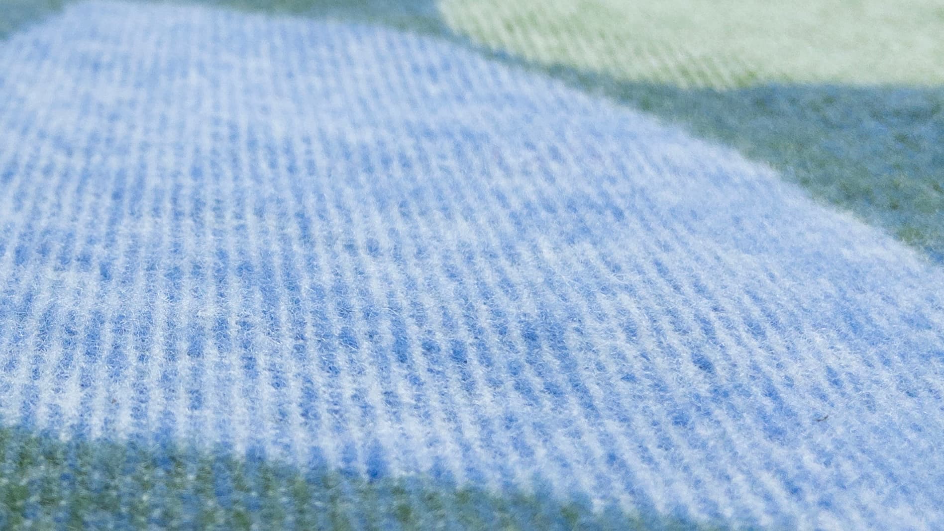 Detaljbild på baksidan av Blåklints filt Barbro i blått och grönt.